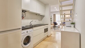 A modern kitchen with a built-in washing machine, a sink, and a stove. - Hanna - Holiday rental Malaga City (Málaga)