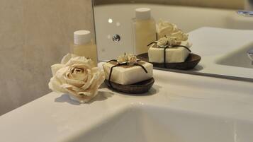 A bathroom sink with toiletries and a decorative rose.