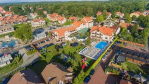 An aerial view of a residential area with multiple houses, a swimming pool, and a small boat dock.