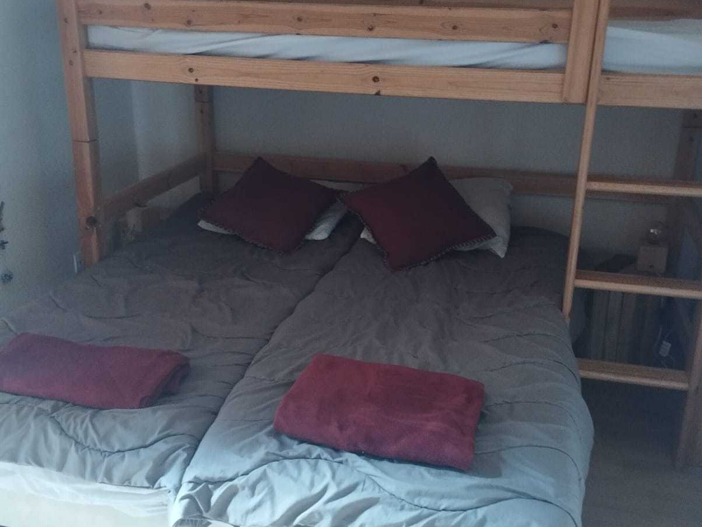 A bunk bed with two pillows and a blanket.