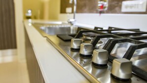 A kitchen with a stainless steel range hood, a sink, and a faucet. - LuxRent Apartment Castello (Torino)