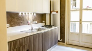 A modern kitchen with a built-in stove, sink, and a radiator. - LuxRent Apartment Castello (Torino)