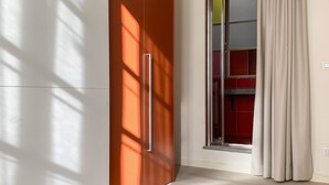 A modern room with a sliding door, a view of a red interior, and a light-colored floor. - LuxRent Apartment Castello (Torino)