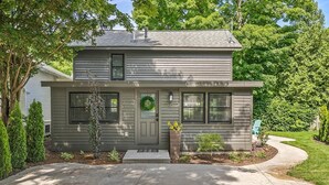 A two-story house with a front porch, a mailbox, and a wreath on the door. - Singapore Stable hot tub walk to Saugatuck! (Saugatuck)