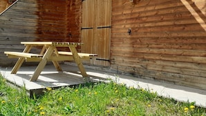 Eine Holzhütte mit einem Picknicktisch vor der Tür und einer Treppe.