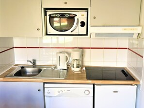 A compact kitchen with a microwave, toaster, coffee maker, sink, and dishwasher. - Charming Chalet in Les Flocons du Soleil - 3 Rooms, 7 Guests, Pool & Sauna Access (La Joue du Loup)