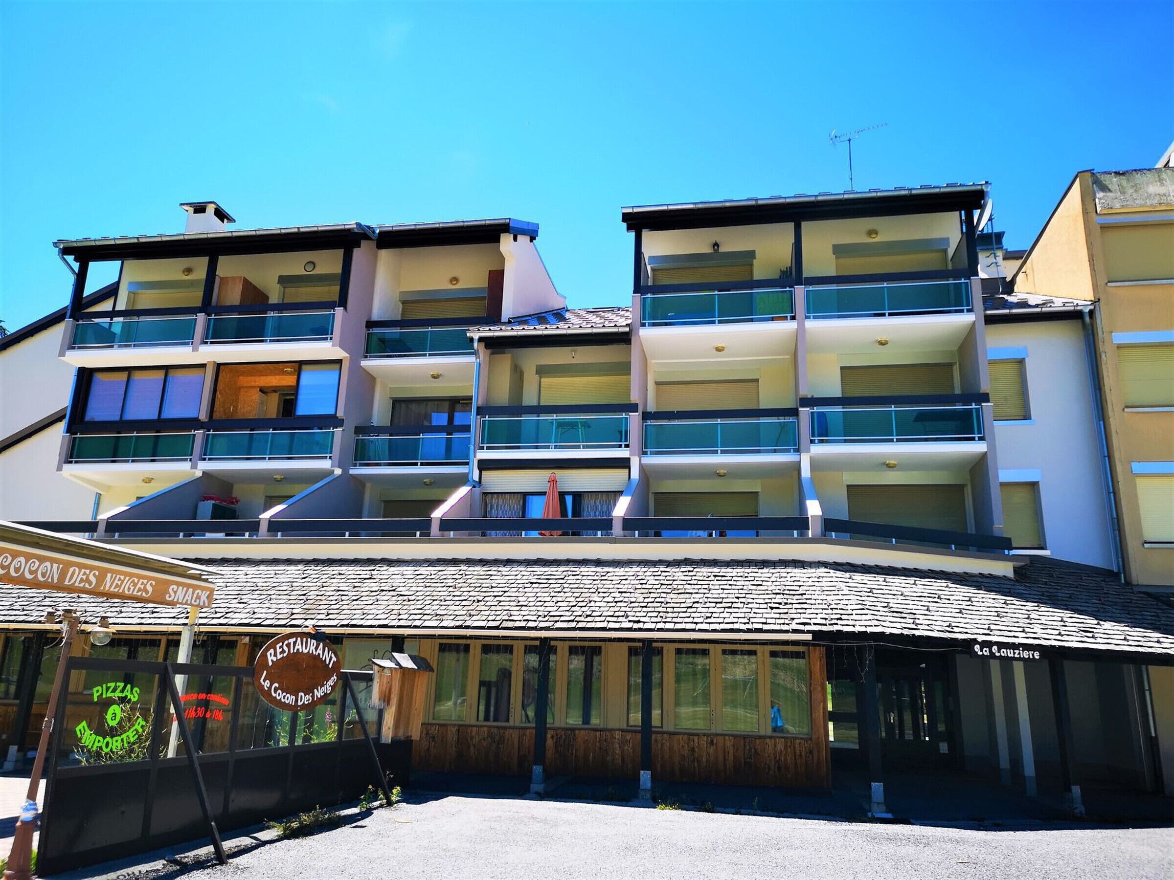Ein mehrstöckiges Hotel mit Balkonen und einem Restaurant im Erdgeschoss.