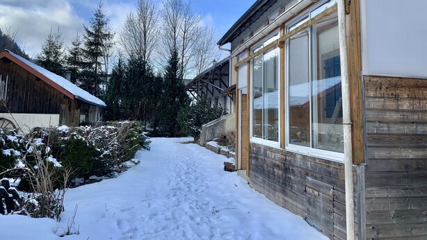 A snow-covered pathway leading to a wooden house with large windows. - Large charming refuge at the water's edge in Gérardmer. Spa / sauna / Wifi (Gérardmer)