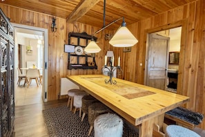 Ein rustikales Holzinterieur mit einer zentralen Insel, Pendelleuchten und einer gemütlichen Sitzecke.