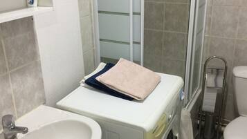 Een haardroger, handdoeken, zeep, toiletpapier