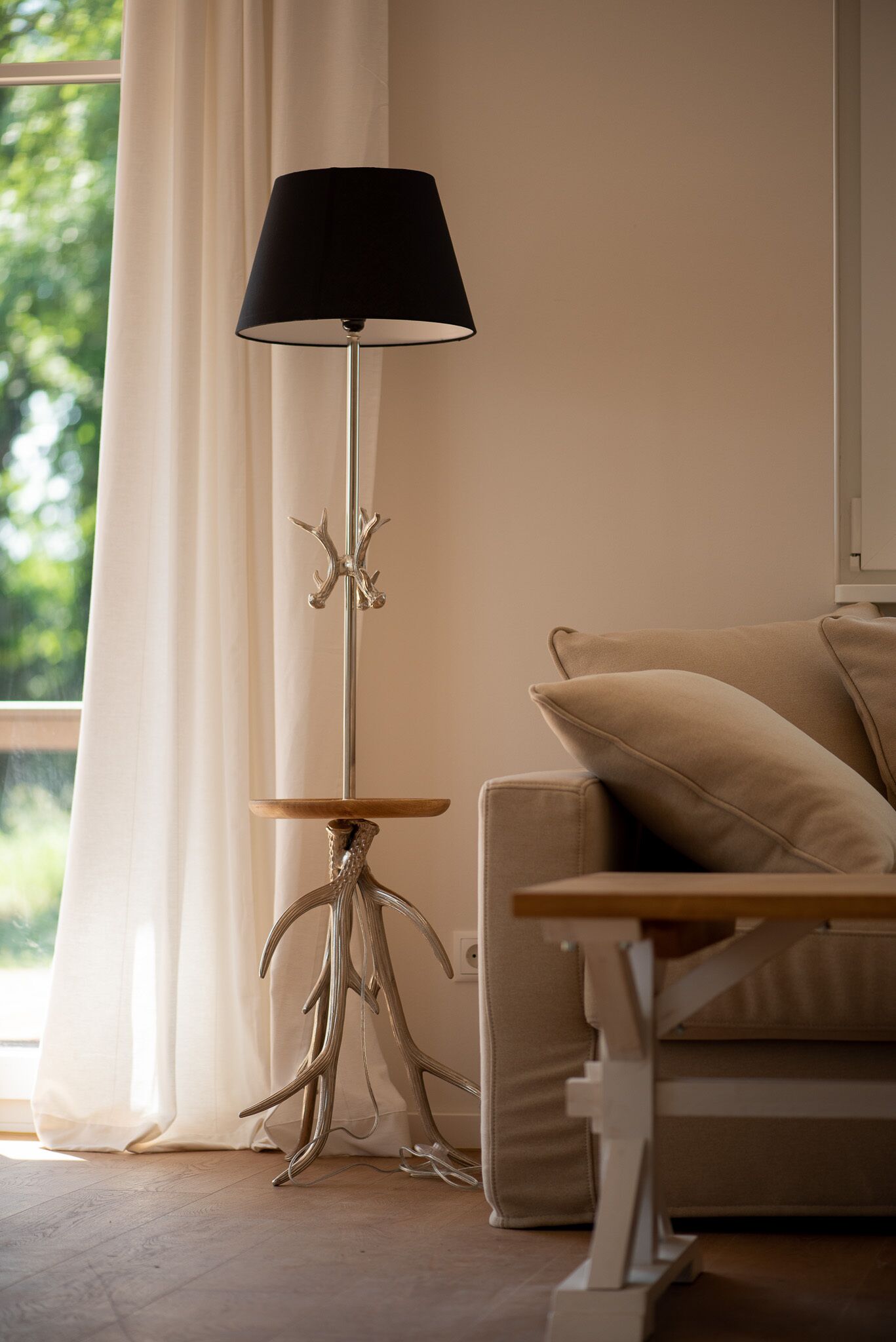 Ein modernes Wohnzimmer mit Stehlampe, einer Couch und einem kleinen Tisch.