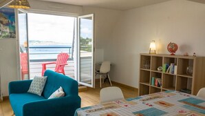 Une pièce avec un canapé de couleur turquoise, une bibliothèque en bois et une table avec un set de table.