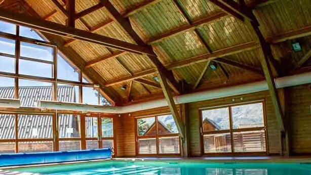 A large indoor swimming pool with a high ceiling and large windows. - Cozy Chalet, Sleeps 7, Pool & Sauna Access, Near Shops & Restaurants (Le Dévoluy-Agnières-en-Dévoluy)