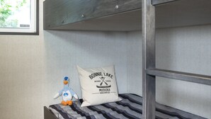 Uma cama beliche com um travesseiro com a etiqueta "BONNIE LAKE" e um pato de pelúcia.