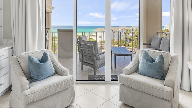 Un balcon avec deux fauteuils, une table et une vue sur l’océan.