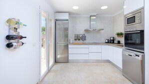 A modern kitchen with white cabinets, stainless steel appliances, and a sliding glass door leading to a balcony. - DONES D'AIGUA 11 - Villa with sea views in Urb. S'Estanyol (Colonia de Sant Pere). Free Wi (Artà)
