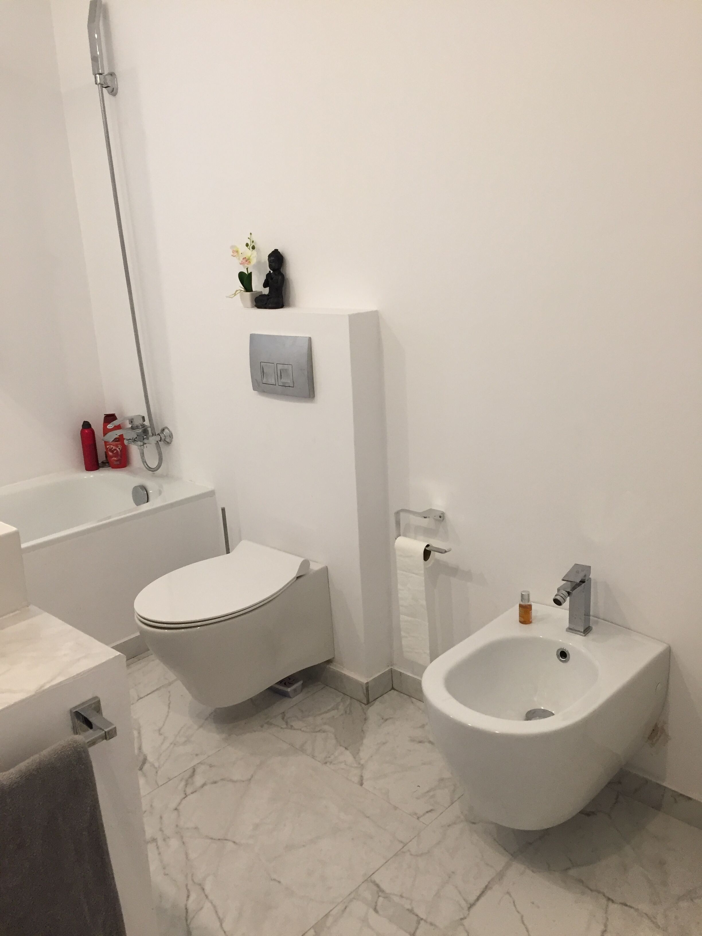 Une salle de bain moderne équipée de toilettes, d’un bidet et d’une baignoire.