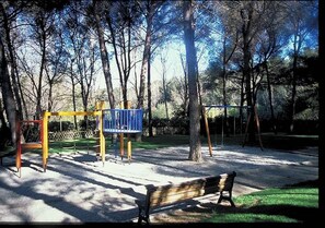 A park with a playground, a bench, and trees. - Homerez - Apt near beach & pool (Six-Fours-les-Plages)