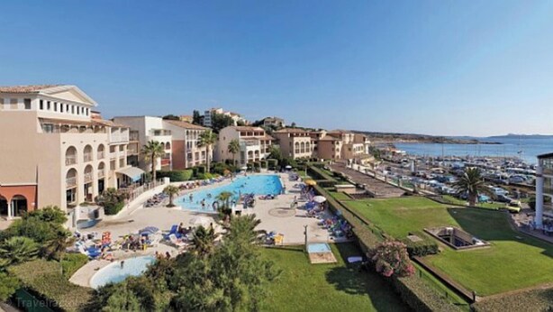 Un resort con piscina, varios edificios y un puerto deportivo.
