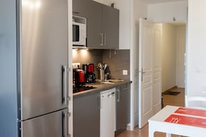 A compact kitchen with stainless steel appliances, a microwave, and a coffee maker. - Homerez - Apt near beach & pool (Six-Fours-les-Plages)