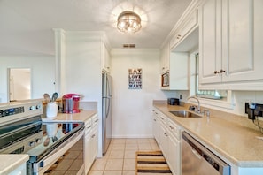 A kitchen with white cabinets, a stainless steel refrigerator, a double oven, a sink, and a countertop with a coffee maker. - 3BR cabin with hot tub, mtn views, nearby lake access; near Tail of the Dragon; free rafting & train (Robbinsville)