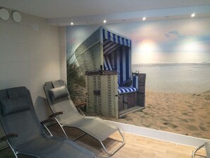 A beach-themed room with two lounge chairs, a small beach hut, and a mural of a beach scene. - Family friendly apartment with 2 bedrooms, terrace and swimming pool (Duhnen)