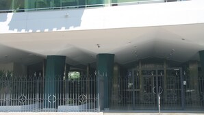 A building entrance with a covered walkway, metal gates, and a sign that reads "central park".