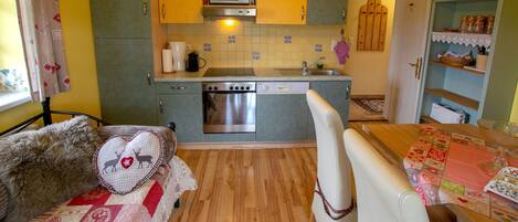 A compact kitchen with a microwave, oven, and sink.