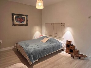 A bedroom with a bed, bedside table, lamp, and a wall-mounted shelf. - Panoramic view of Marseille and sunset, calm, nature and garden (Marseille)