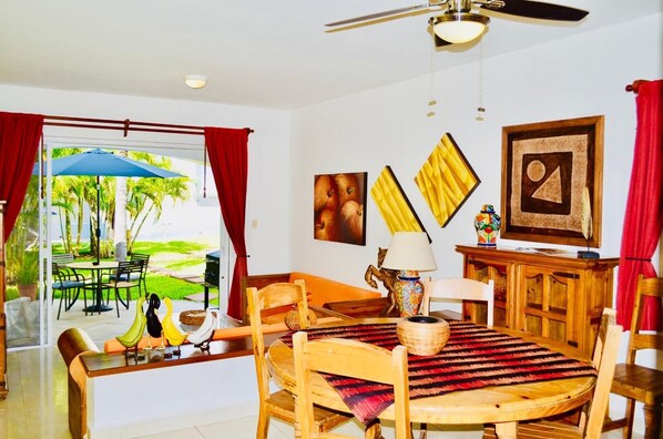 A dining area with a round wooden table, chairs, and a ceiling fan.