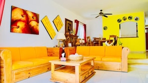 A living room with a wooden sofa set, a wooden coffee table, and a ceiling fan. - Superior Villa Playacar – 500 m from the Beach & 5th Avenue (Playa del Carmen)