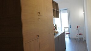 A modern kitchen with wooden cabinets, a countertop, and a dining area with a table and chairs. - The penthouse view with panoramic view (Palermo)