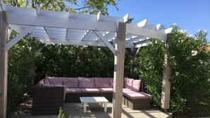 A covered outdoor seating area with a sofa and a coffee table.