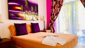 Een slaapkamer met een bed, kussens, een schilderij, een lamp en een raam met gordijnen.