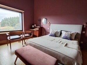 Ein Schlafzimmer mit Bett, Schreibtisch, Stuhl und Fenster.
