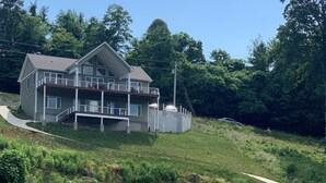 A two-story house with a balcony, a dock, and a pathway leading to a gazebo over water. - Lake Front ★ No Wake w/ Dock ★ Gameroom ★ Carved FirePit ★ 2nd House Available (LaFollette)