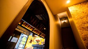 An arched doorway leading to a room with a stone wall and a wooden ceiling. - Bayya Hotel Phu Quoc (Phu Quoc)