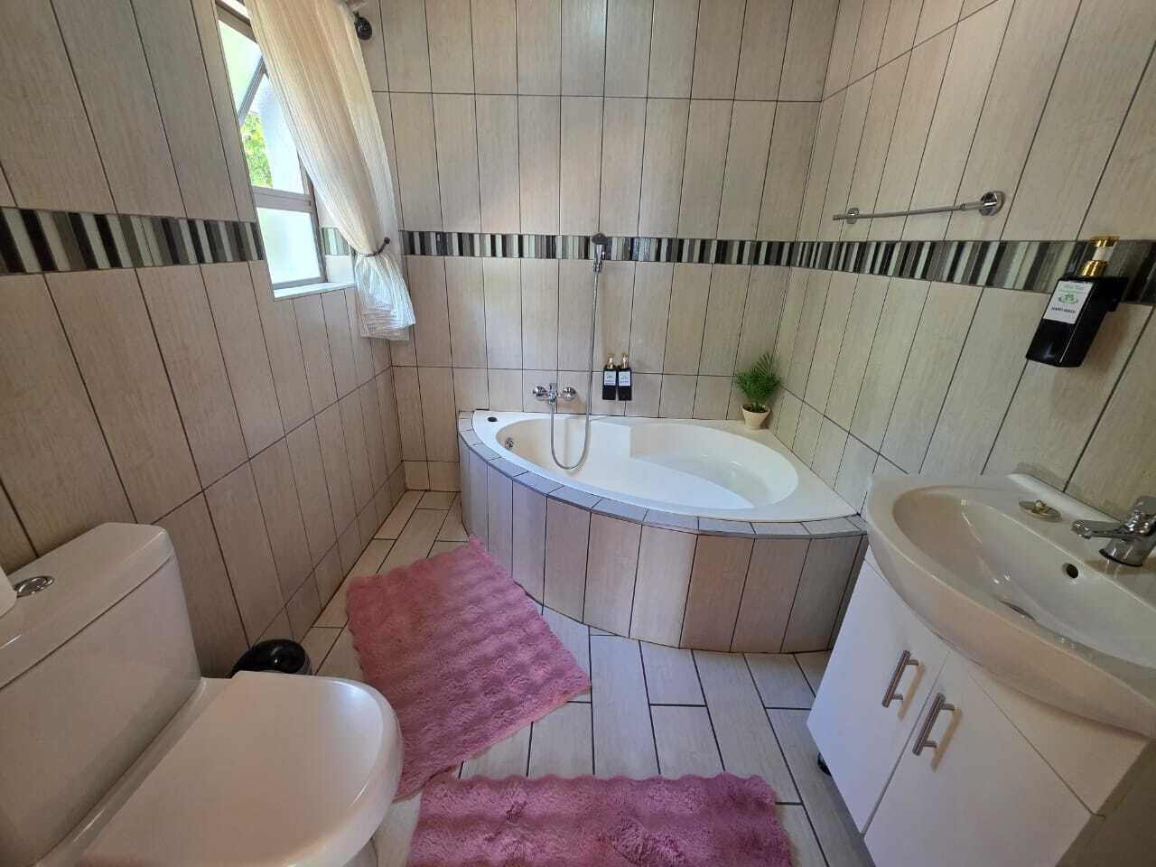 A bathroom with a toilet, a bathtub, a sink, and a shower.