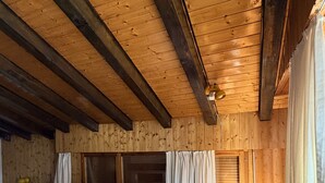 A cozy cabin room with a wooden ceiling, a bed, a chair, and a table. - Diablerets D 048 - MOUNTAIN apartment 4 pers (Veysonnaz)