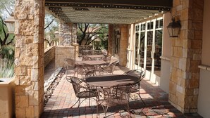 An outdoor patio with stone walls, metal tables, and chairs. - Truly a Las Sendas Resort home! (Mesa)