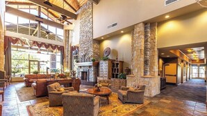 A spacious lobby with a high ceiling, stone fireplace, multiple seating areas, and large windows allowing natural light. - Truly a Las Sendas Resort home! (Mesa)