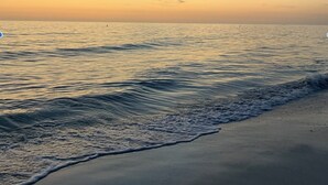 A beach with gentle waves and a clear sky.