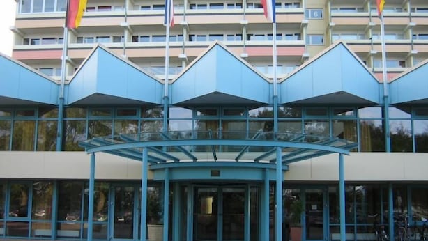A modern building with a glass entrance and multiple flags. - Vacation Apartment K1213 with a View of the Baltic Sea (Schönberg OT Holm)