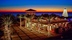 A beachfront hotel with a covered patio, palm trees, and a view of the ocean at sunset. - HUGE % OFF, Private Pool | 6 Bikes ☀️129 Reviews | Gulf Views | Seagrove 30A ☀️Beach Gear (Santa Rosa Beach)