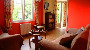 Una sala de estar acogedora con chimenea, una estantería y un televisor.