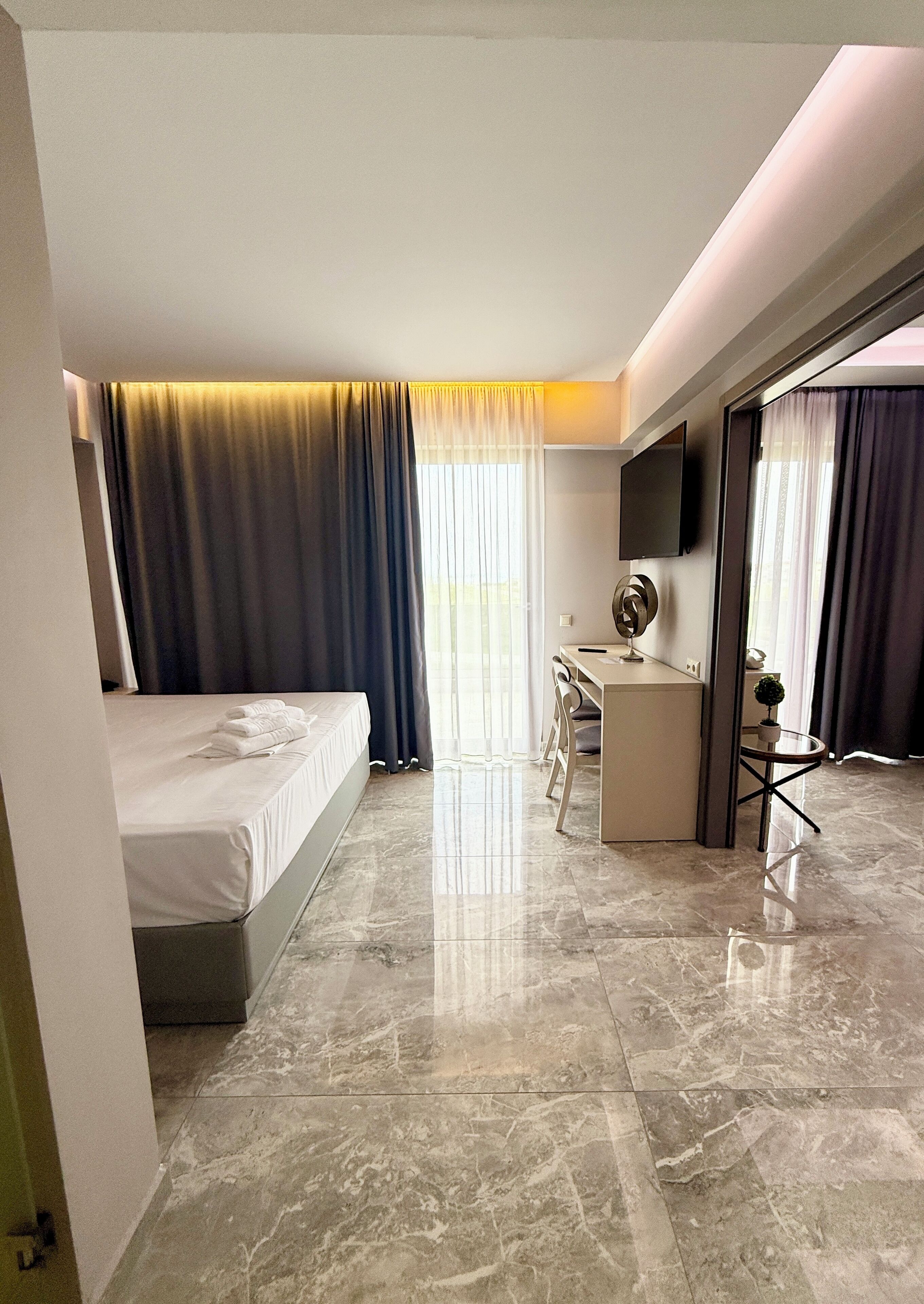 Habitación de hotel moderna con cama, escritorio y zona de estar.