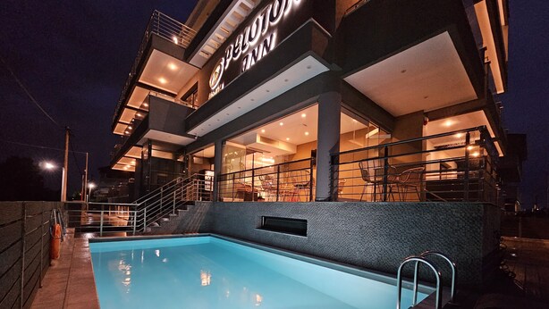 Un hôtel moderne doté d’une piscine, d’un espace extérieur aménagé et d’une entrée bien éclairée.