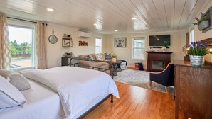 Una habitación amplia con cama, sofá, chimenea y televisión.