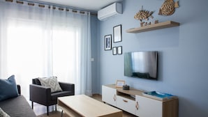 Una sala de estar moderna con un sofá, una mesa de centro, un televisor y un aparador.