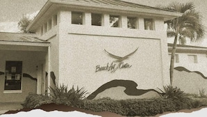 Un bâtiment sur lequel on peut lire l’inscription « Centre d’art de la plage », avec une façade simple, un toit plat et un petit balcon.